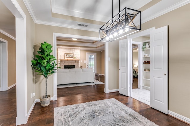 13914 Overlook Ln, Forney, TX 75126 - foyer entrance with wood finished floors, ornamental molding, a raised ceiling, a fireplace, and baseboards