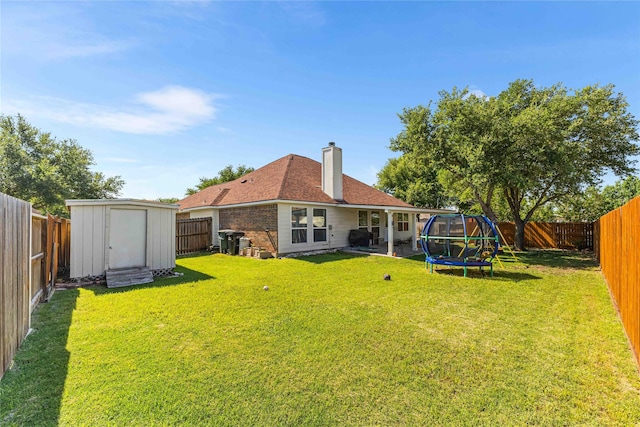 5608 Aberdeen Ct, Temple, TX 76502 - back of house with a trampoline, a chimney, brick siding, and a patio area
