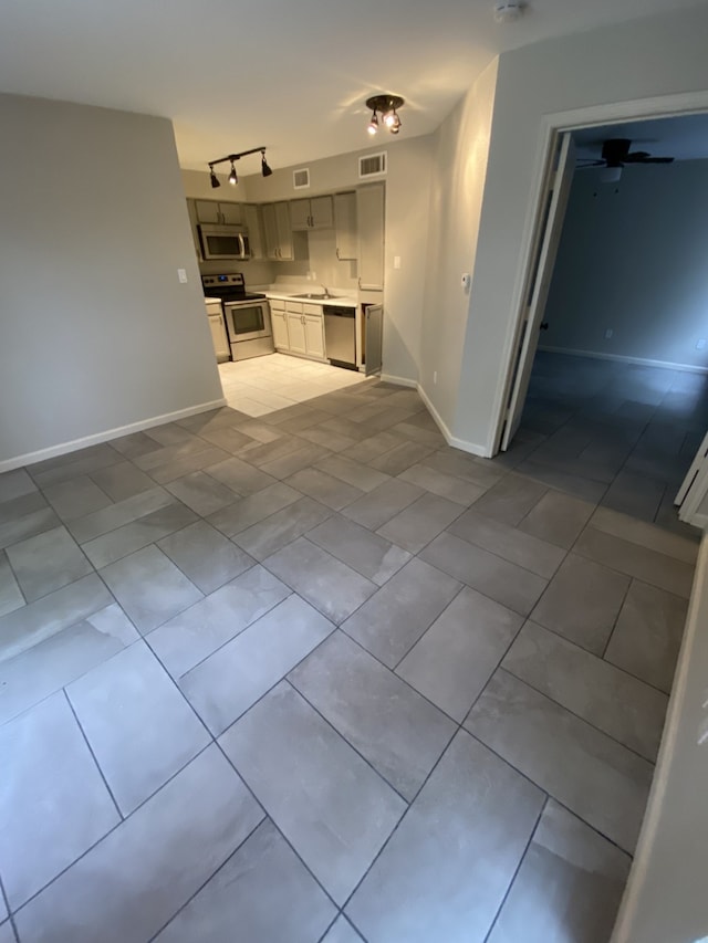 9823 Walnut St Unit L112, Dallas, TX 75243 - unfurnished living room featuring baseboards, tile patterned flooring, and track lighting