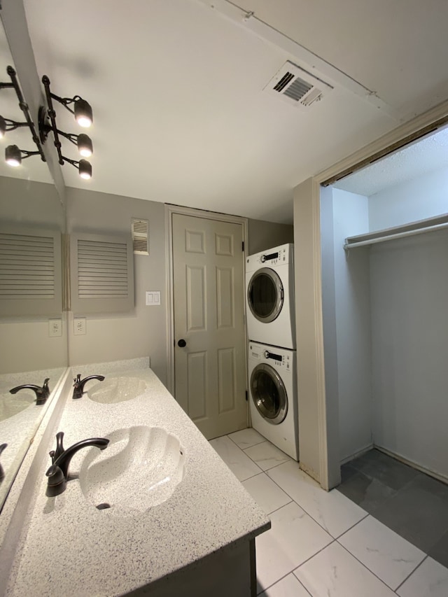 9823 Walnut St Unit L112, Dallas, TX 75243 - bathroom featuring estacked washer and dryer, double vanity, and marble look tiles