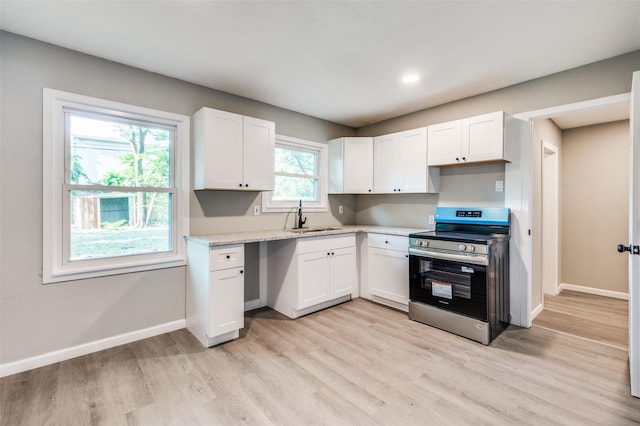 6632 Avalon Dr, Watauga, TX 76148 - kitchen featuring stainless steel range with electric stovetop, a sink, white cabinets, light wood finished floors, and recessed lighting