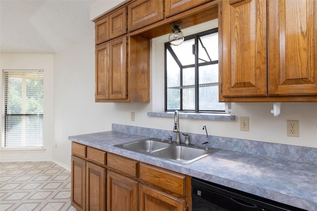 4007 Cherokee Ct, Granbury, TX 76048 - kitchen featuring black dishwasher, a sink, and brown cabinetry