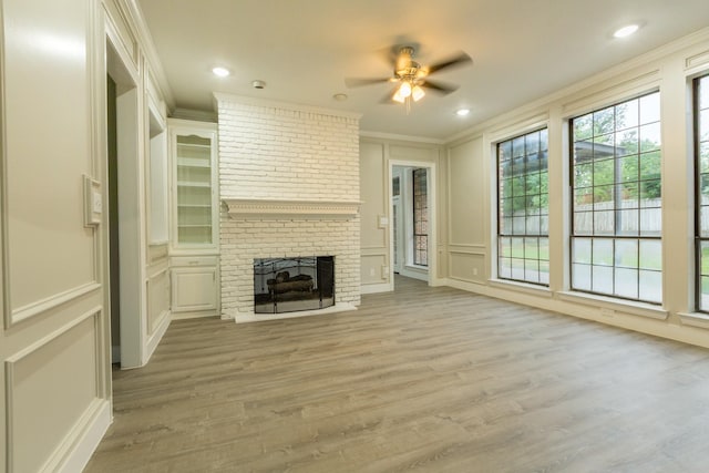 2302 Tiffany Ct, Garland, TX 75043 - unfurnished living room featuring a decorative wall, ornamental molding, ceiling fan, light wood-style flooring, and a fireplace