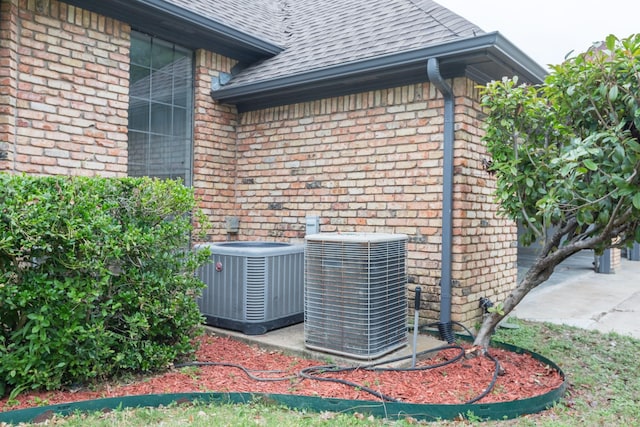 2302 Tiffany Ct, Garland, TX 75043 - exterior view of central AC, brick siding, a shingled roof, and a downspout