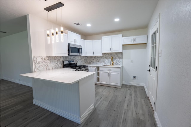 1620 E King St, Sherman, TX 75090 - kitchen featuring appliances with stainless steel finishes, light wood-type flooring, a peninsula, decorative backsplash, and recessed lighting