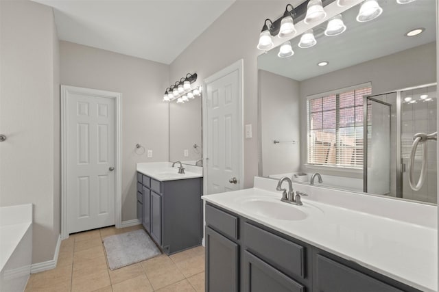 7008 Clipper Dr, Grand Prairie, TX 75054 - full bathroom featuring two vanities, a garden tub, a stall shower, tile patterned flooring, and baseboards