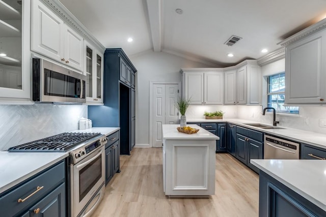 928 Westbrook Dr, Plano, TX 75075 - kitchen with appliances with stainless steel finishes, a sink, blue cabinetry, light wood finished floors, and backsplash