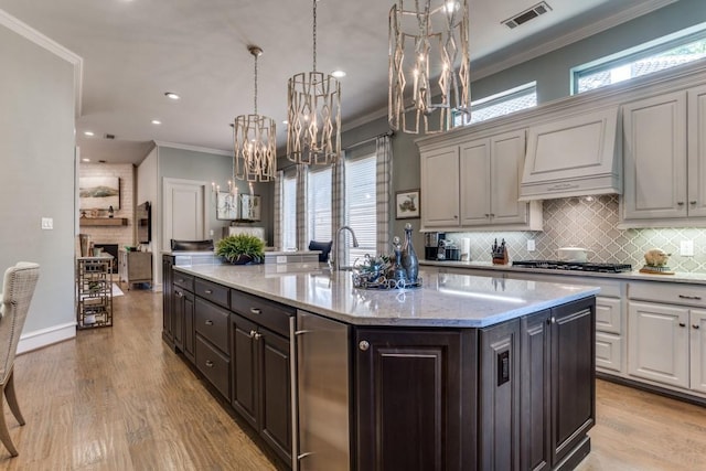 2709 Redding Dr, Plano, TX 75093 - kitchen with a chandelier, stainless steel gas cooktop, ornamental molding, backsplash, and plenty of natural light