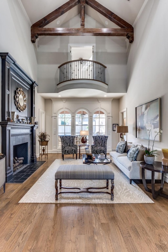 2709 Redding Dr, Plano, TX 75093 - living room featuring high vaulted ceiling, beamed ceiling, wood finished floors, a tile fireplace, and baseboards