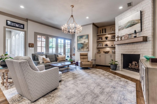 2709 Redding Dr, Plano, TX 75093 - living room featuring a chandelier, wood finished floors, ornamental molding, a brick fireplace, and recessed lighting
