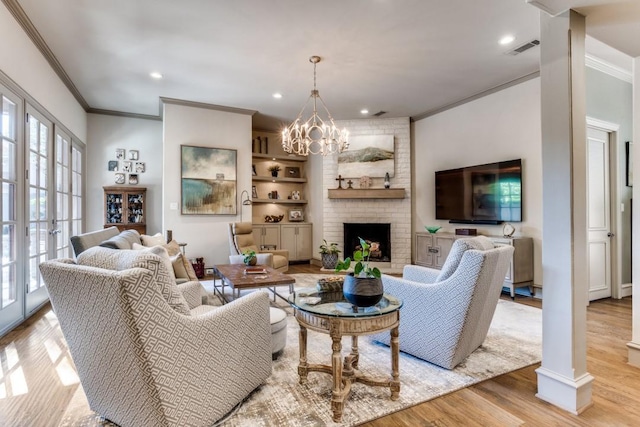 2709 Redding Dr, Plano, TX 75093 - living room featuring crown molding, light wood-style floors, a fireplace, a chandelier, and recessed lighting