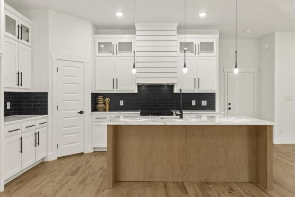 301 Bay Ct, Gun Barrel City, TX 75156 - kitchen featuring light wood-style floors, backsplash, an island with sink, light countertops, and recessed lighting