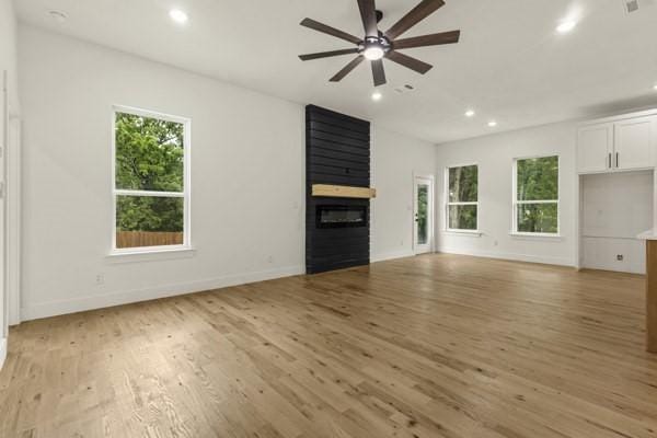 301 Bay Ct, Gun Barrel City, TX 75156 - unfurnished living room with recessed lighting, a ceiling fan, light wood-type flooring, a large fireplace, and baseboards
