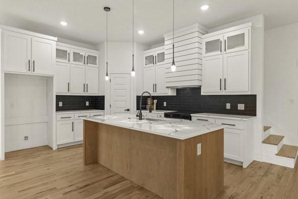 301 Bay Ct, Gun Barrel City, TX 75156 - kitchen featuring light wood-style floors, tasteful backsplash, a sink, white cabinets, and recessed lighting