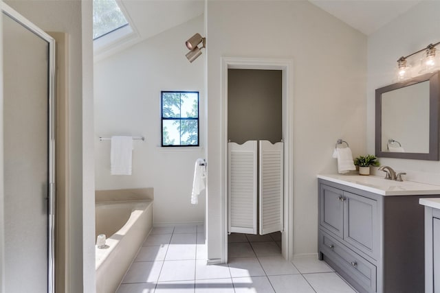 3631 Hilltop Ln, Plano, TX 75023 - bathroom featuring vaulted ceiling, vanity, a garden tub, tile patterned flooring, and a skylight