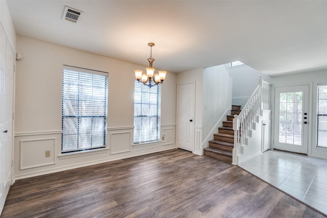 3631 Hilltop Ln, Plano, TX 75023 - foyer with a chandelier, stairs, a wainscoted wall, wood finished floors, and a decorative wall