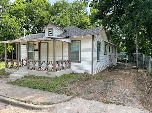 2722 Hector St, Dallas, TX 75210 - view of front of home with covered porch, a gate, and a shingled roof