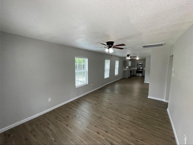 2722 Hector St, Dallas, TX 75210 - unfurnished living room with ceiling fan, dark wood-type flooring, a textured ceiling, and baseboards