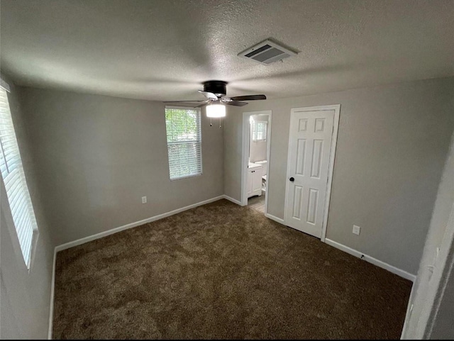 2722 Hector St, Dallas, TX 75210 - unfurnished bedroom with dark carpet, baseboards, connected bathroom, a textured ceiling, and ceiling fan