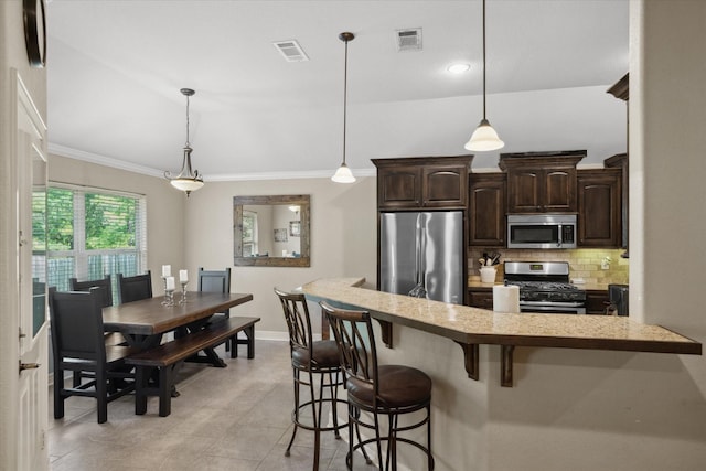 365 Maggie Cir, Flint, TX 75762 - kitchen featuring stainless steel appliances, dark brown cabinetry, a breakfast bar, crown molding, and decorative backsplash
