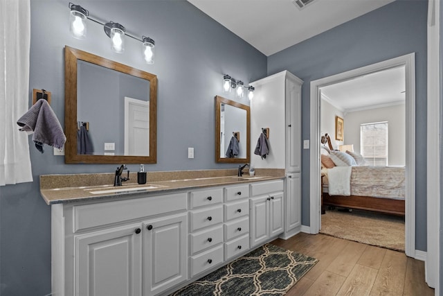 301 Northcreek Dr, Chandler, TX 75758 - ensuite bathroom with double vanity, wood finished floors, baseboards, and ornamental molding