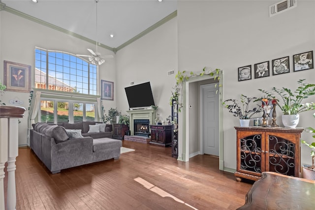 301 Northcreek Dr, Chandler, TX 75758 - living room with crown molding, a high ceiling, a brick fireplace, ceiling fan, and hardwood / wood-style floors