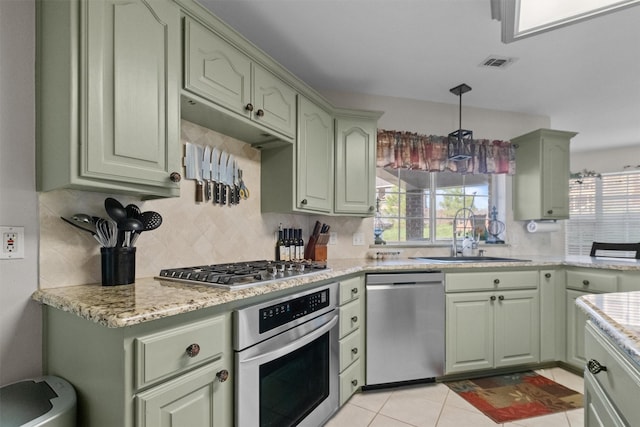 301 Northcreek Dr, Chandler, TX 75758 - kitchen featuring appliances with stainless steel finishes, green cabinets, a sink, tasteful backsplash, and decorative light fixtures