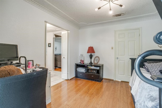 217 NE Rosamond St, Burleson, TX 76028 - bedroom with a textured ceiling, ornamental molding, and light wood-style flooring