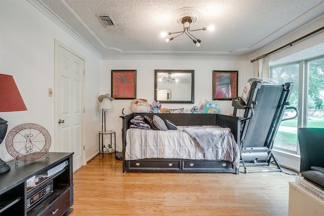 217 NE Rosamond St, Burleson, TX 76028 - bedroom with a textured ceiling, wood finished floors, a chandelier, and crown molding