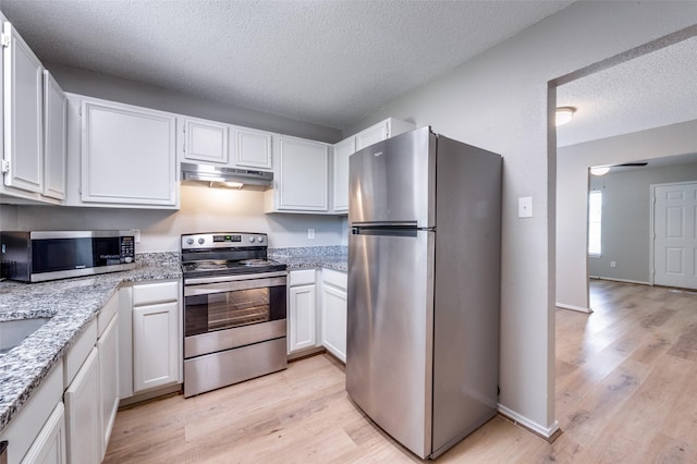 2521 Markland St, Irving, TX 75060 - kitchen with appliances with stainless steel finishes, under cabinet range hood, light wood-type flooring, a textured ceiling, and light stone countertops