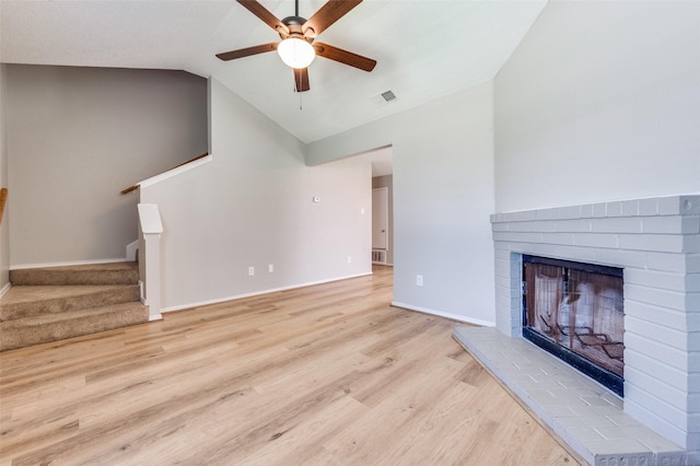 2521 Markland St, Irving, TX 75060 - unfurnished living room with ceiling fan, light wood finished floors, vaulted ceiling, stairway, and a fireplace