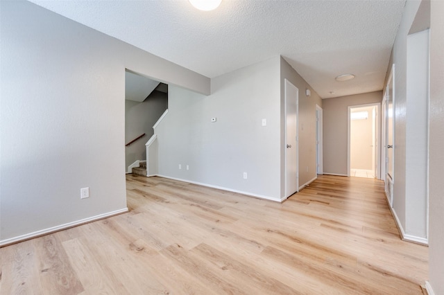 2521 Markland St, Irving, TX 75060 - empty room with wood finished floors, stairway, baseboards, and a textured ceiling