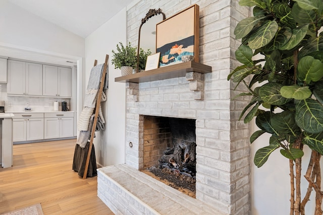 328 High Brook Dr, Richardson, TX 75080 - living room featuring light wood-type flooring, lofted ceiling, and a fireplace