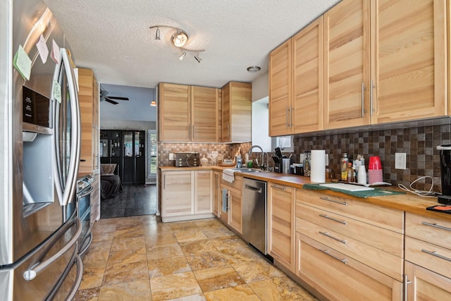 3801 Silver Maple Dr, Carrollton, TX 75007 - kitchen featuring appliances with stainless steel finishes, wooden counters, a sink, decorative backsplash, and light brown cabinetry
