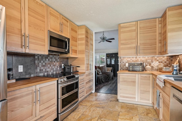 3801 Silver Maple Dr, Carrollton, TX 75007 - kitchen with stainless steel appliances, butcher block countertops, light brown cabinets, tasteful backsplash, and a textured ceiling