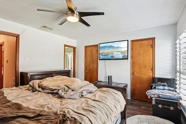 3801 Silver Maple Dr, Carrollton, TX 75007 - bedroom featuring dark wood-style floors, a textured ceiling, and ceiling fan