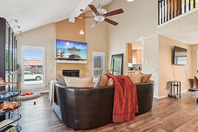 3801 Silver Maple Dr, Carrollton, TX 75007 - living area with wood finished floors, ceiling fan, a fireplace, beamed ceiling, and high vaulted ceiling