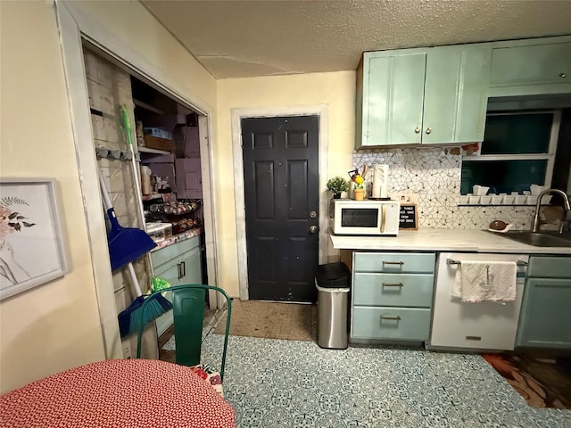 11717 Crumpton Dr, Balch Springs, TX 75180 - kitchen featuring green cabinets, white microwave, a sink, backsplash, and light countertops