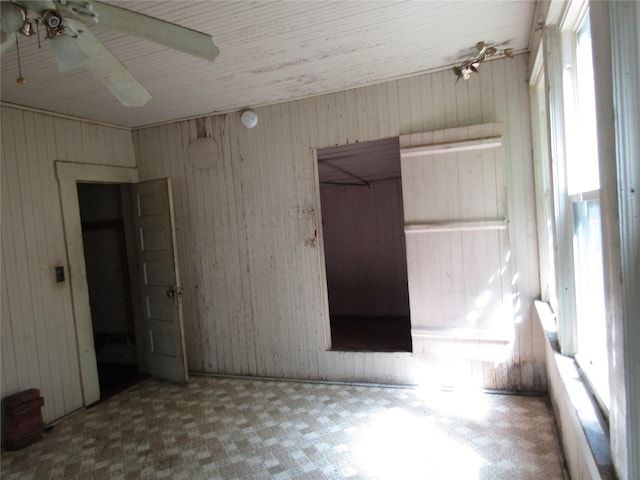 507 N Beaton St, Corsicana, TX 75110 - unfurnished bedroom featuring tile patterned floors, wood walls, and ceiling fan