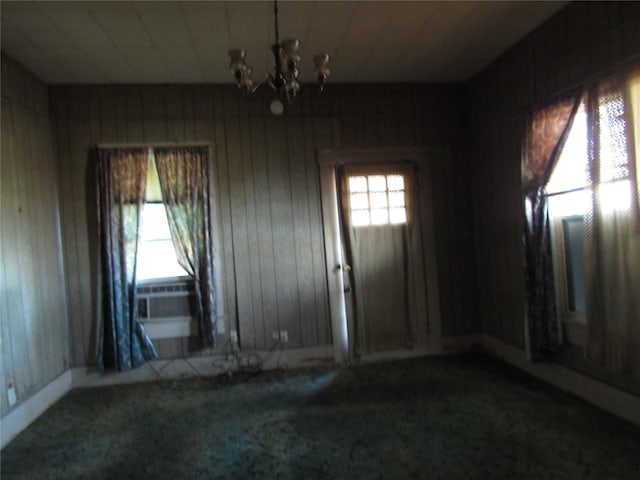 507 N Beaton St, Corsicana, TX 75110 - spare room with carpet, a chandelier, wooden walls, and baseboards
