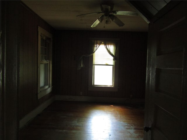 507 N Beaton St, Corsicana, TX 75110 - unfurnished room featuring wood finished floors, a ceiling fan, wooden walls, and baseboards