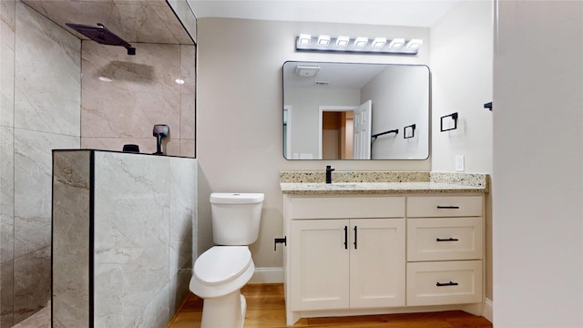 2210 Mcclure St, Irving, TX 75062 - bathroom with vanity, toilet, walk in shower, wood finished floors, and baseboards