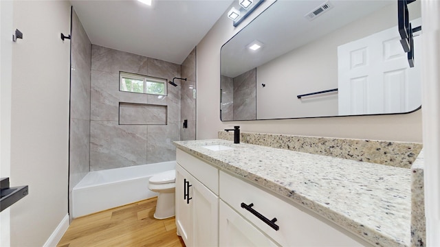 2210 Mcclure St, Irving, TX 75062 - bathroom with toilet, wood finished floors, vanity, bathtub / shower combination, and baseboards
