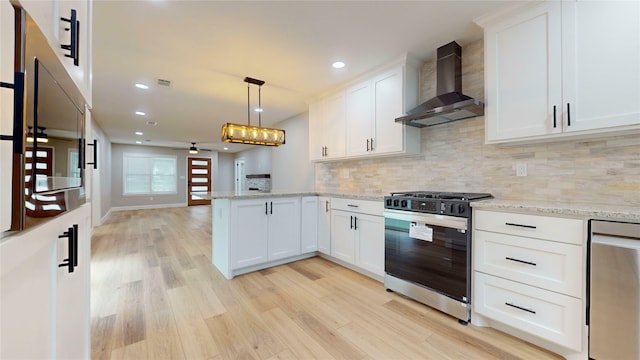 2210 Mcclure St, Irving, TX 75062 - kitchen with wall chimney exhaust hood, appliances with stainless steel finishes, light wood-type flooring, a peninsula, and tasteful backsplash