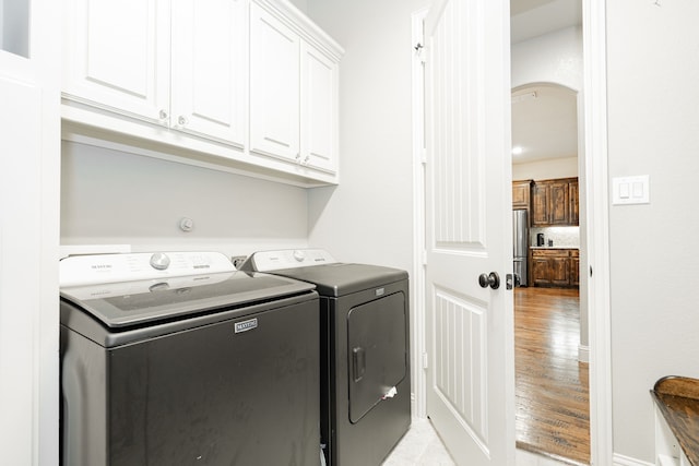817 Calm Crest Dr, Rockwall, TX 75087 - laundry area with washer and dryer, cabinet space, light wood finished floors, and arched walkways