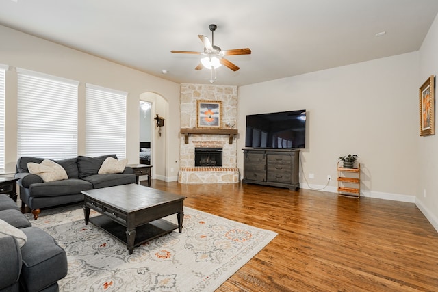 817 Calm Crest Dr, Rockwall, TX 75087 - living room with ceiling fan, wood finished floors, arched walkways, a fireplace, and baseboards