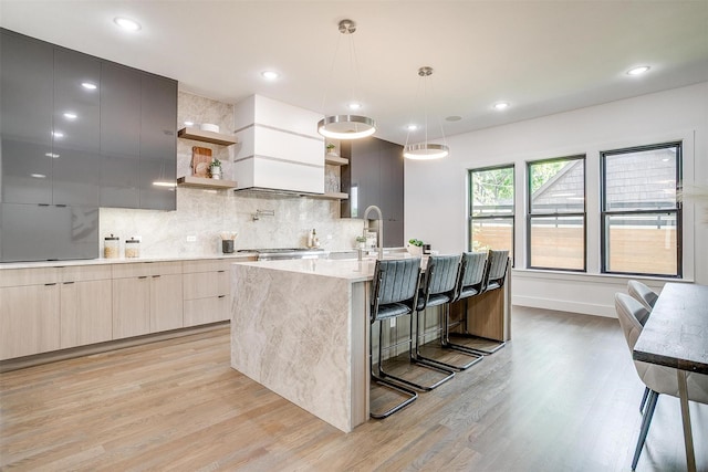 3916 W 5th St, Fort Worth, TX 76107 - kitchen with modern cabinets, open shelves, light wood-type flooring, a kitchen island with sink, and decorative backsplash