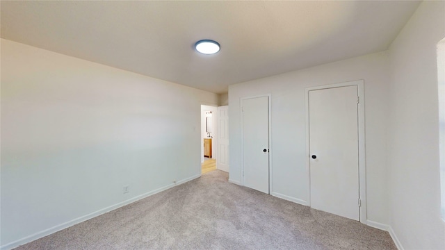 3809 Grover Ave, Fort Worth, TX 76106 - unfurnished bedroom featuring carpet, baseboards, and two closets