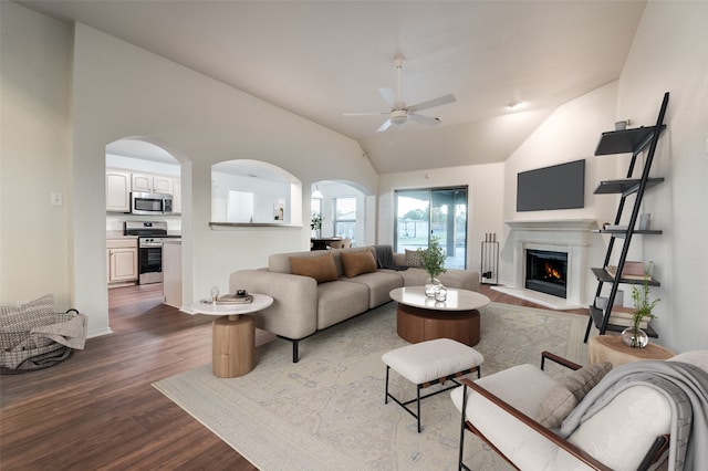 10260 E Rancho Diego Ln, Crowley, TX 76036 - living room with dark wood-type flooring, a ceiling fan, arched walkways, a warm lit fireplace, and vaulted ceiling