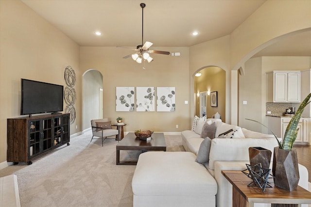 13929 Castlegate Dr, Frisco, TX 75035 - living area featuring arched walkways, ceiling fan, baseboards, recessed lighting, and light carpet